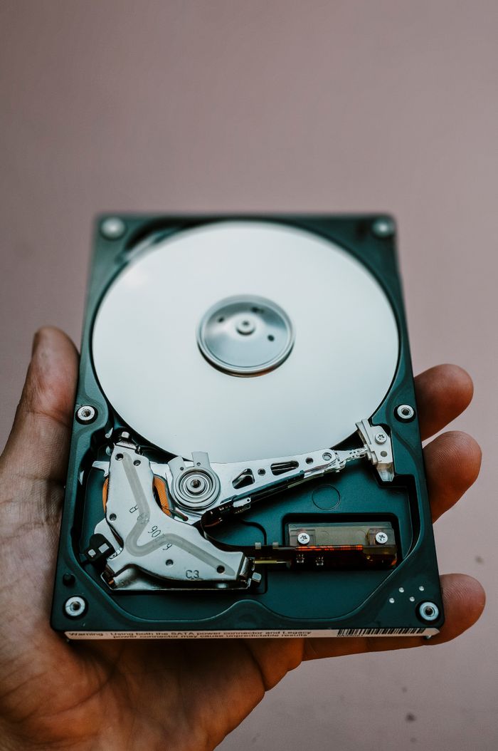 services-04 Close-up view of an open hard drive held in a hand, illustrating data storage technology.