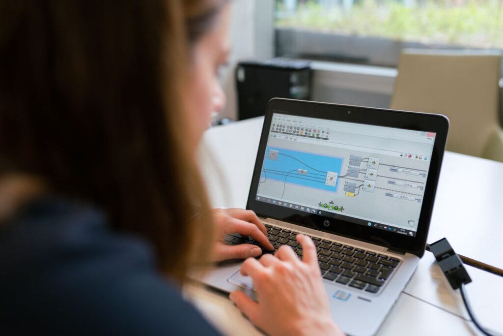 A woman engineer focuses on software analysis using a laptop indoors.