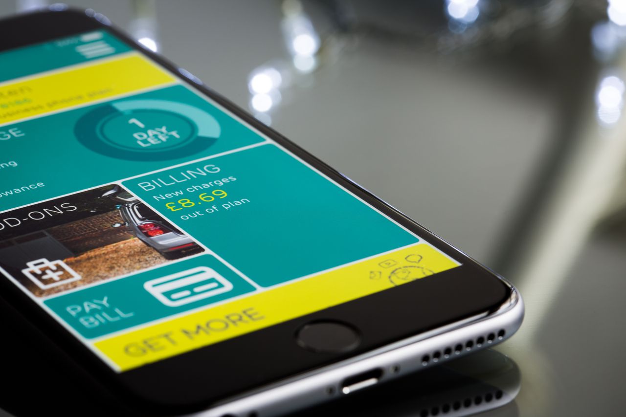 services-img Close-up of a smartphone displaying a billing app interface on a reflective surface.